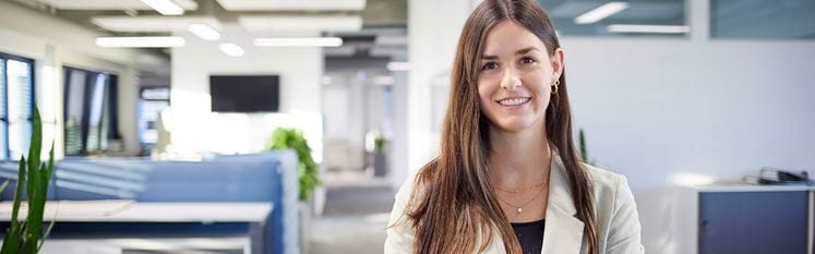 Mitarbeiterin schaut in Kamera