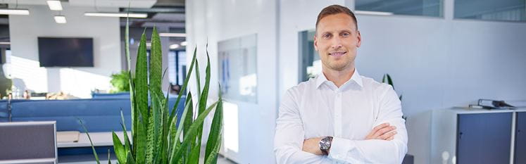 Mitarbeiter schaut in Kamera